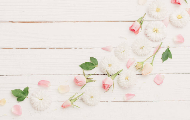 roze en witte bloemen op witte houten achtergrond - Foto, afbeelding