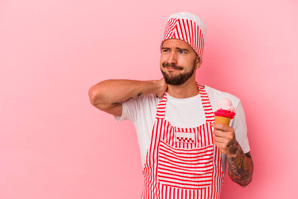 Молодий кавказький чоловік з татуюваннями тримає морозиво ізольовано на рожевому фоні, торкаючись голови, думаючи і роблячи вибір
. - Фото, зображення