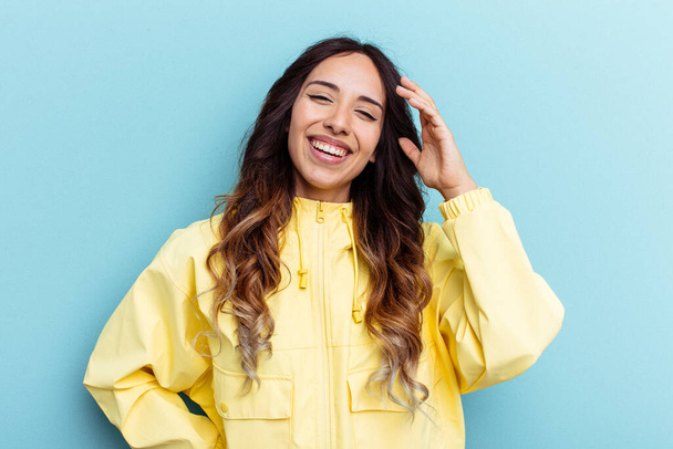 Young mexican woman isolated on blue background joyful laughing a lot. Happiness concept. - Photo, Image