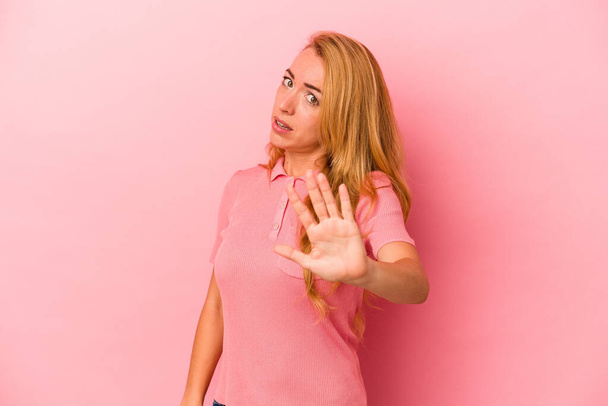 Caucasian blonde woman isolated on pink background being shocked due to an imminent danger - Valokuva, kuva