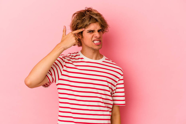 Young caucasian man with make up isolated on pink background covering ears with hands. - Photo, Image