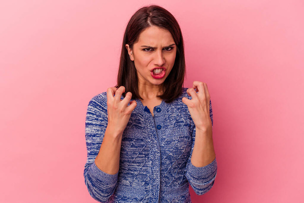 Junge kaukasische Frau isoliert auf rosa Hintergrund verärgert schreien mit angespannten Händen. - Foto, Bild
