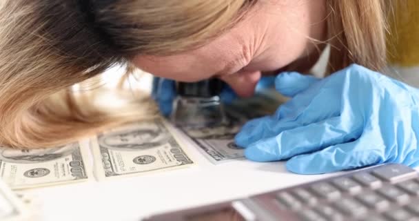 Donna esperto guardando i soldi attraverso lente di ingrandimento 4k film slow motion - Filmati, video