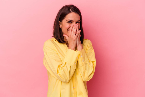 Young caucasian woman isolated on pink background laughing about something, covering mouth with hands. - Photo, Image