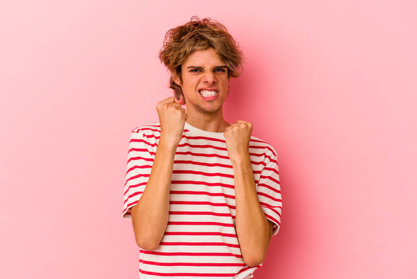 Jovem caucasiano homem com maquiagem isolada no fundo rosa chateado gritando com as mãos tensas. - Foto, Imagem