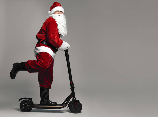 Noel Baba elektrikli scooter kullanıyor. - Fotoğraf, Görsel