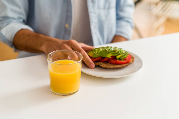 Молодий змішаний гоночний чоловік сніданок на своїй кухні
 - Фото, зображення