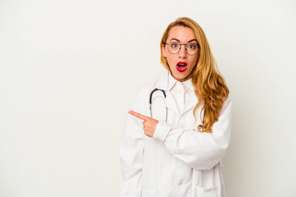 Mujer doctora caucásica aislada sobre fondo blanco apuntando hacia un lado - Foto, imagen