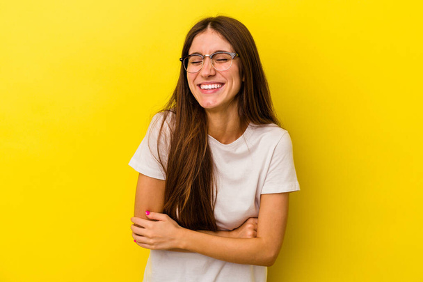 Young caucasian woman isolated on yellow background laughing and having fun. - Photo, Image