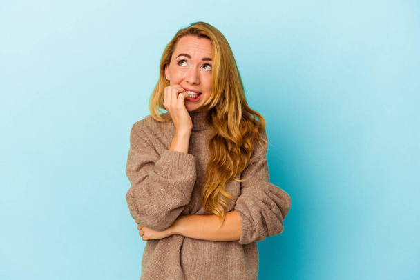 Caucasian woman isolated on blue background biting fingernails, nervous and very anxious. - Photo, Image