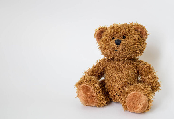 Мягкая игрушка медведь сидит на белом фоне - Фото, изображение