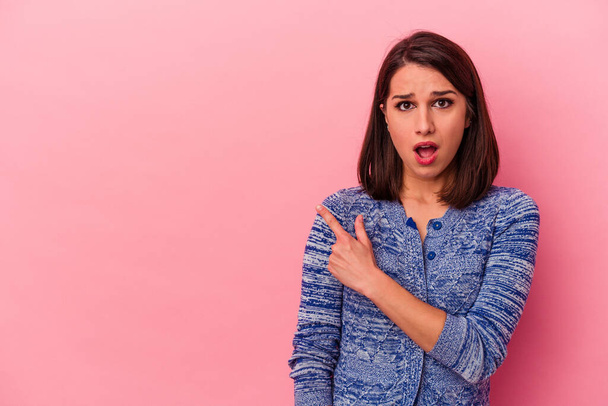 Young caucasian woman isolated on pink background pointing to the side - Photo, Image