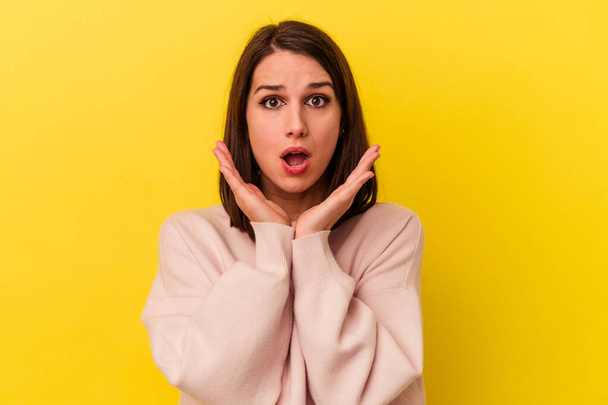 Young caucasian woman isolated on yellow background surprised and shocked. - Photo, Image