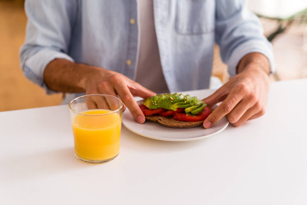 młody mieszane wyścig człowiek jedzenie śniadanie w jego kuchni - Zdjęcie, obraz