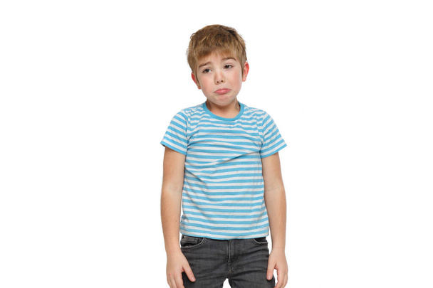 Upset cute little boy in striped clothes isolated on white background. - Fotoğraf, Görsel