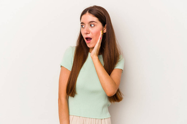 Young caucasian woman isolated on white background being shocked because of something she has seen. - Photo, Image