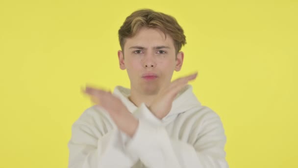 Jongeman toont geen teken door arm gebaar op gele achtergrond  - Video