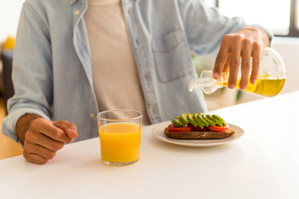 Giovane uomo di razza mista fare colazione nella sua cucina - Foto, immagini