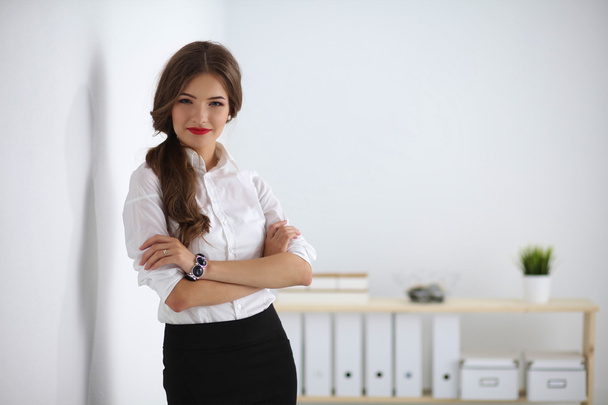 Attractive businesswoman with her arms crossed  standing in off - Foto, imagen