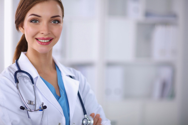 Portret van jonge vrouw arts met witte jas staan in hosp - Foto, afbeelding