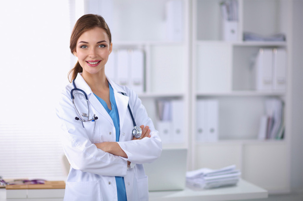Portrait of young woman doctor with white coat standing in hosp - Foto, Imagen