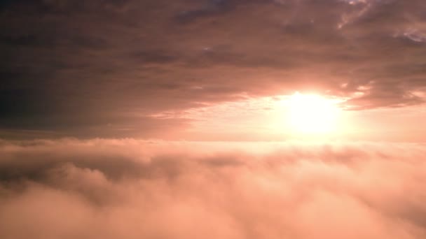 Aerial View. Flying in fog, fly in mist over the early morning clouds in the rising sun. Aerial camera shot. Flight above the clouds towards the sun with the mist clouds floating by. Misty weather - Footage, Video