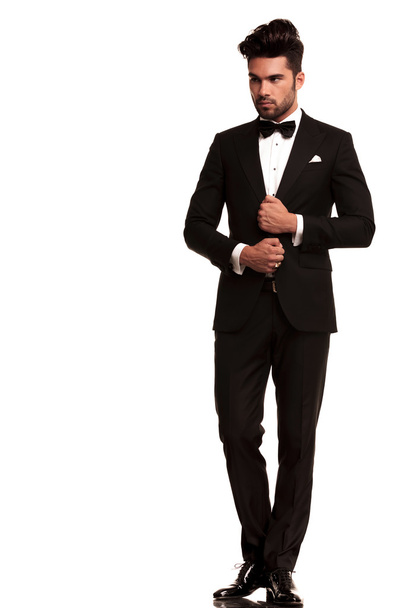 Elegant young fashion man adjusting his tuxedo - Photo, Image