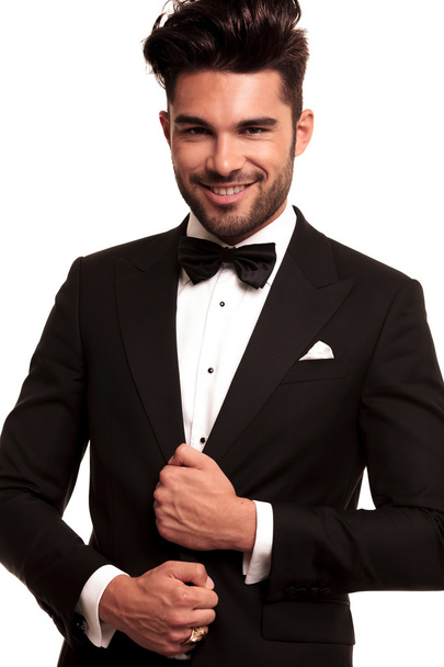 smiling young groom in tuxedo and bowtie  - Photo, Image