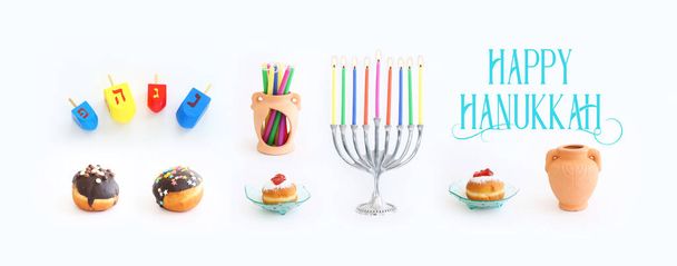 Náboženství obraz židovské dovolené Chanuka pozadí s menorah (tradiční svícen), koblihy a svíčky na bílém pozadí - Fotografie, Obrázek