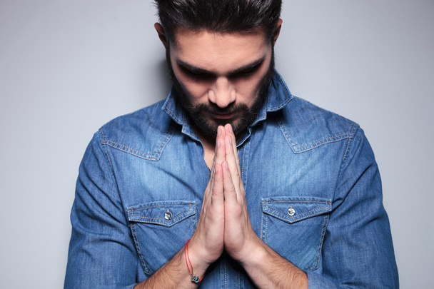 Man in blue shirt praying - Valokuva, kuva