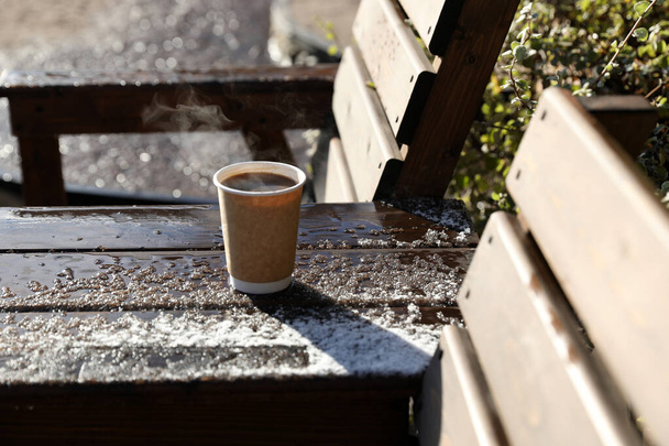 Gorąca czarna kawa na drewnianym stole na zewnątrz, śnieg, późna jesień - Zdjęcie, obraz