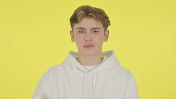 Junger Mann zeigt kein Zeichen mit dem Finger auf gelbem Hintergrund  - Filmmaterial, Video