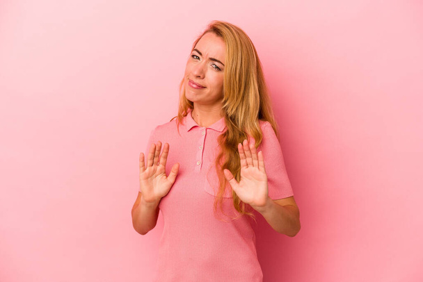 Καυκάσια ξανθιά γυναίκα απομονωμένη σε ροζ φόντο απορρίπτοντας κάποιον που δείχνει μια χειρονομία αηδίας. - Φωτογραφία, εικόνα