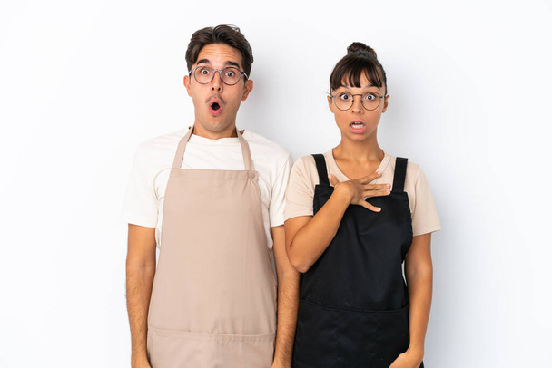 Restaurant mixed race waiters isolated on white background with surprise and shocked facial expression - Photo, Image