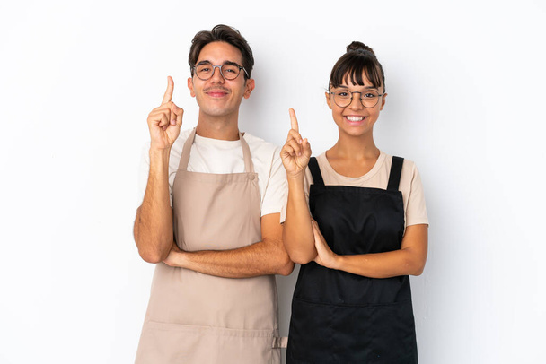 Serveurs mixtes restaurant isolé sur fond blanc montrant et levant un doigt en signe du meilleur - Photo, image