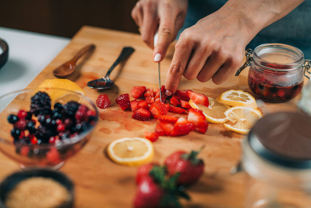 Aardbeien snijden in de keuken. Vruchtenfermentatie. - Foto, afbeelding