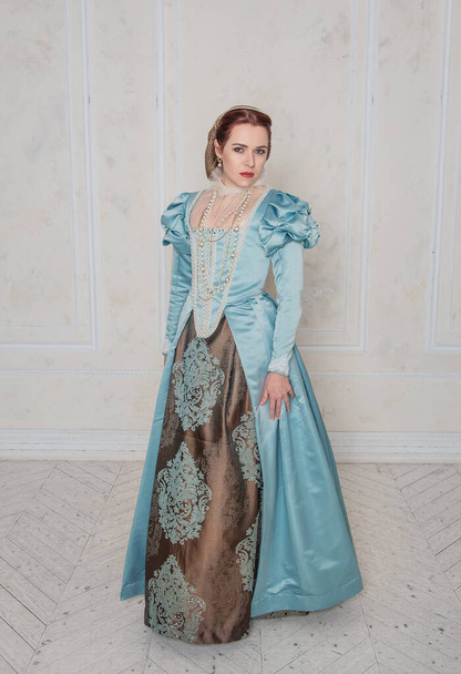 Belle jeune femme dans le style médiéval robe bleue dans la chambre - Photo, image