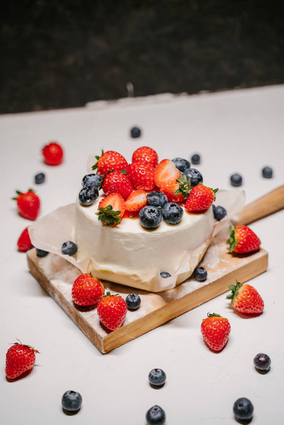 small strawberry bento cake. garnished with strawberries and blueberries on a white background - Valokuva, kuva