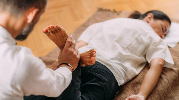 Terapeuta Estirando piernas de mujer. Masaje shiatsu.  - Foto, Imagen