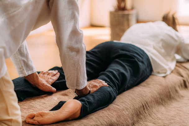 Therapeut masseert vrouwenbenen. vrouw krijgen shiatsu been massage.  - Foto, afbeelding