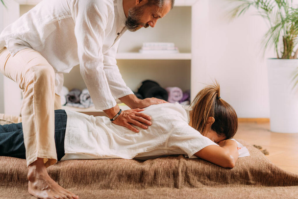 Mulher desfrutando de massagem nas costas shiatsu, deitado no tapete de massagem shiatsu.    - Foto, Imagem