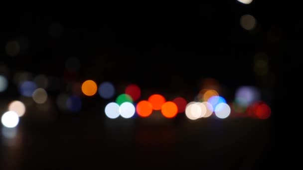 Hermoso bokeh brillante en el fondo oscuro borroso por la noche. El bokeh colorido redondo brilla de las luces del coche en la calle de la ciudad. Desenfocado con borroso. Luces de ciudad desenfocadas. Tráfico bokeh. Abstracto - Metraje, vídeo