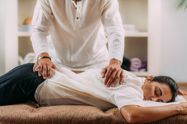 Therapist massaging womans back. Woman getting shiatsu back massage.  - Foto, imagen