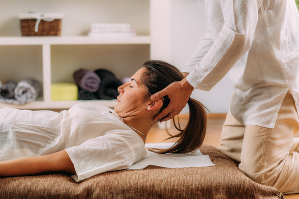 Therapeutin streckt Frauen den Nacken. Shiatsu-Massage.  - Foto, Bild