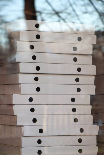 Desfocado muitas caixas brancas na janela de um serviço de entrega de pizza. Foco suave. - Foto, Imagem