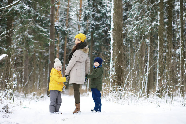 Šťastná rodina si hraje a směje se v zimě venku ve sněhu. Zimní den City Parku. - Fotografie, Obrázek