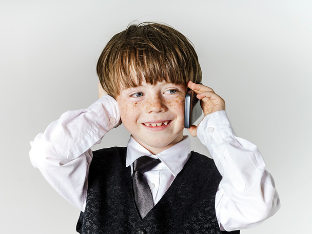Emotional red-haired boy with mobile phone - Photo, image