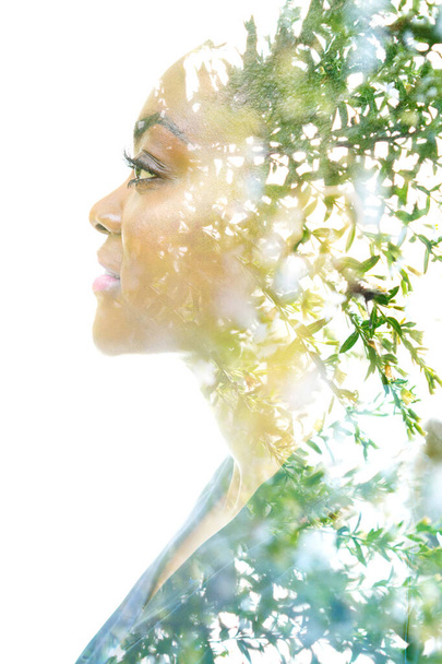 A profile portrait of an attractive woman combined with foliage. Double exposure. - Zdjęcie, obraz