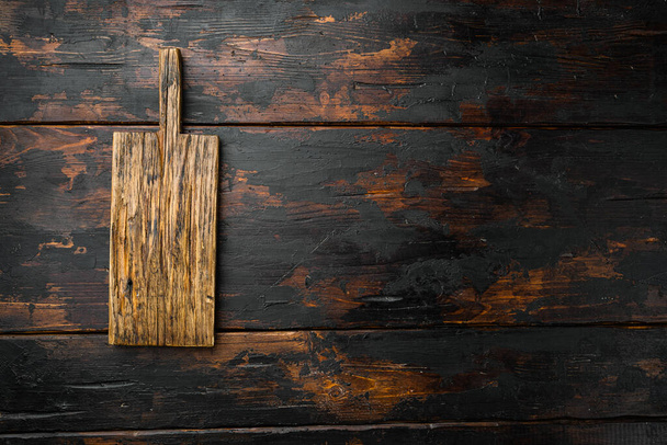 Старый набор разделочной доски, плоский вид сверху, с копировальным пространством для текста или еды, на старом темном деревянном фоне стола - Фото, изображение
