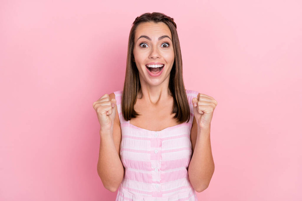 Photo of young girl amazed rejoice victory achievement fists hands win lottery isolated over pink color background - Foto, afbeelding